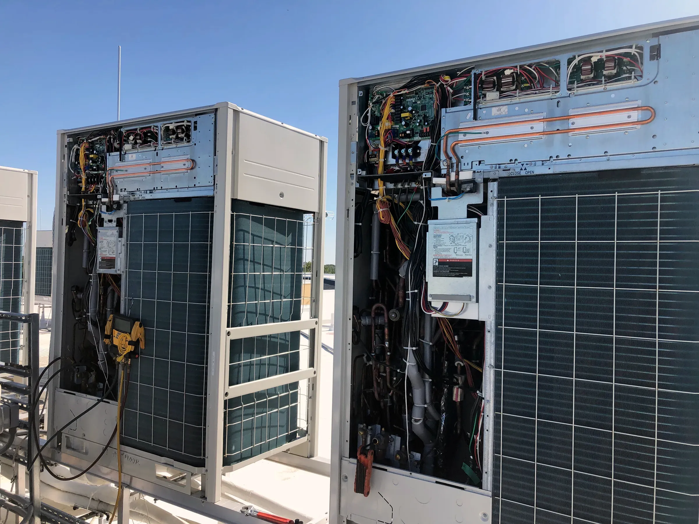 Legacy servicing complex commercial HVAC equipment with access panels open